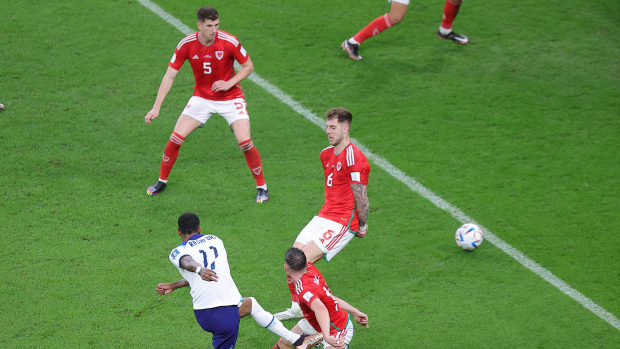 Marcus Rashford pictured (bottom left) shooting to score England's third goal in a 3-0 win over Wales at the 2022 FIFA World Cup in Qatar